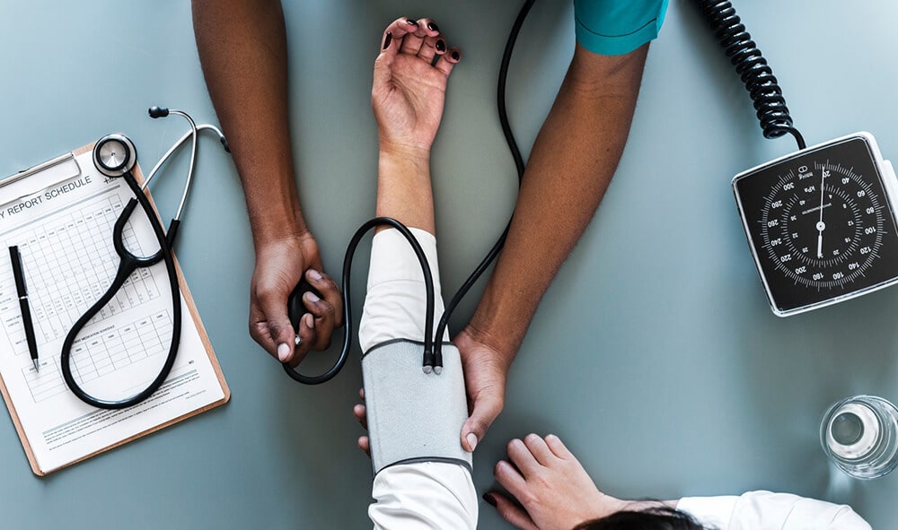 Doctor taking patient's blood pressure