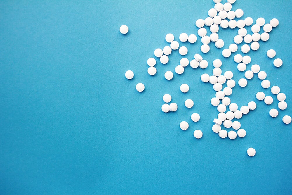 White pills on blue background 