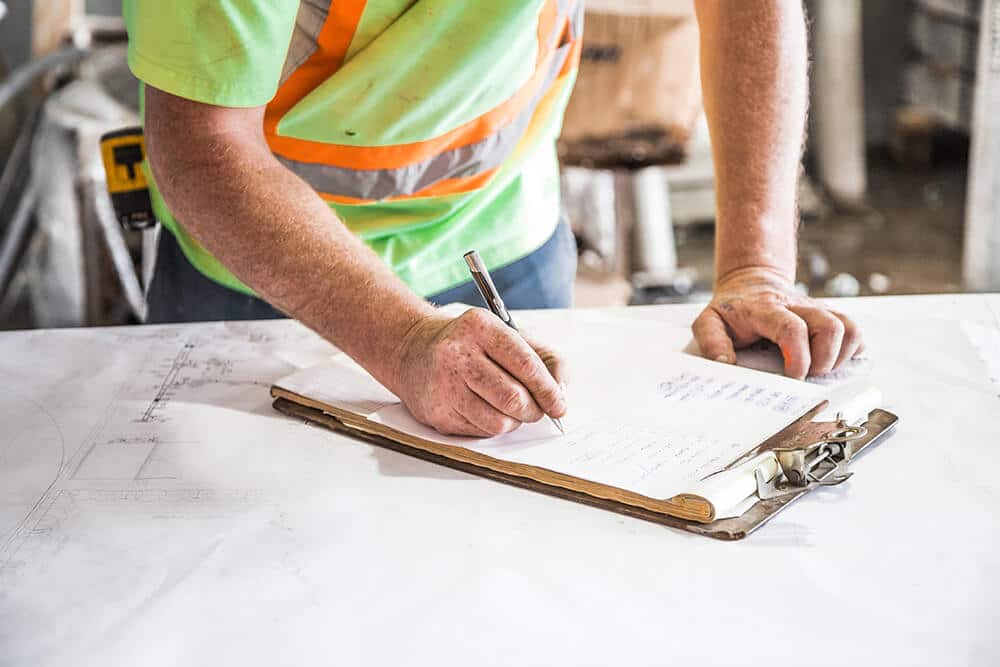 Construction worker signing papers