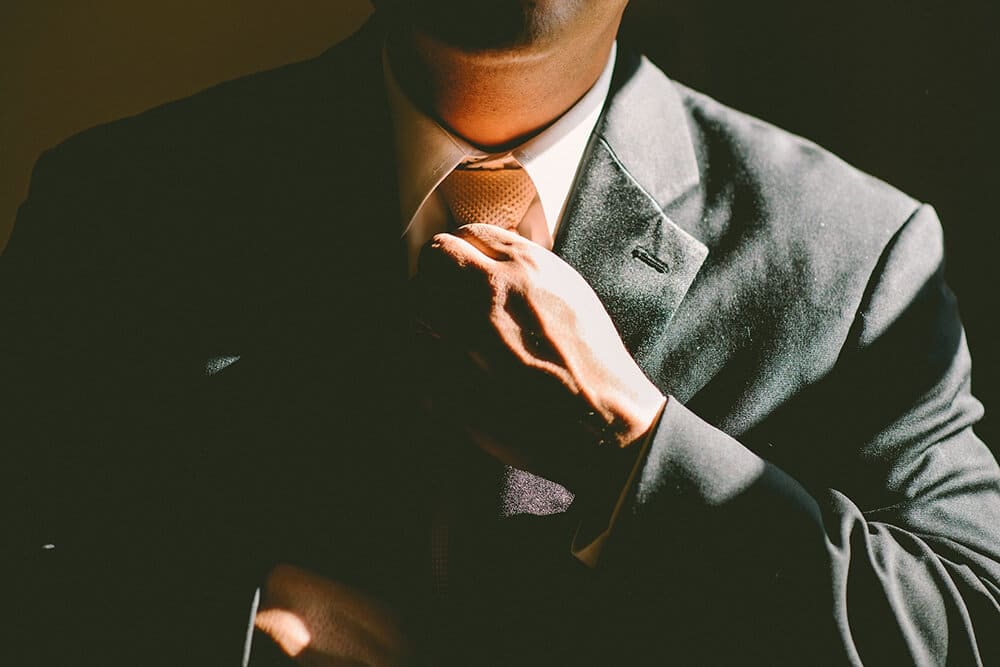 Closeup of man straightening tie