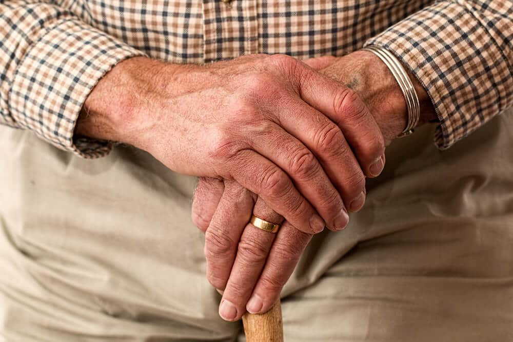 Older person holding own hand